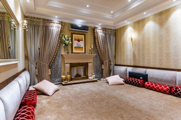 Luxury interior design with natural fiber carpet, silk curtains, and upholstered seating around a classic fireplace