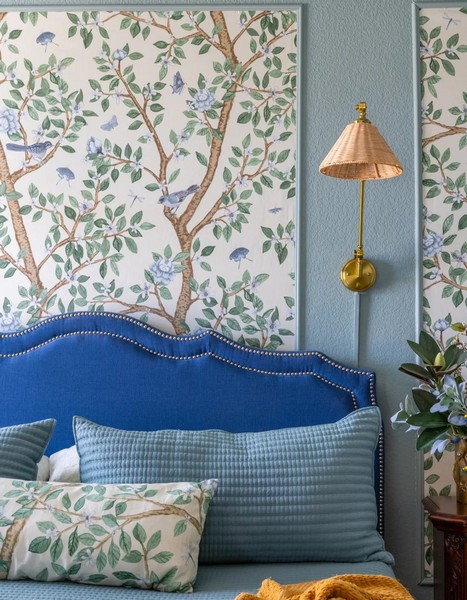 Botanical print natural textile wall covering with birds and leaves pattern in a blue bedroom interior